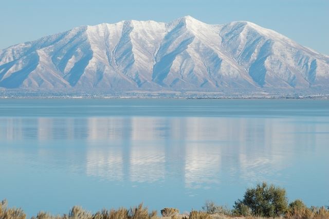 Mountain Range Sitting Behind Large Blue Lake