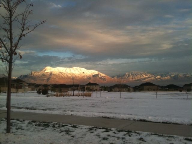 Snow on the Ground Near Residential Area With Mountain Range in Background