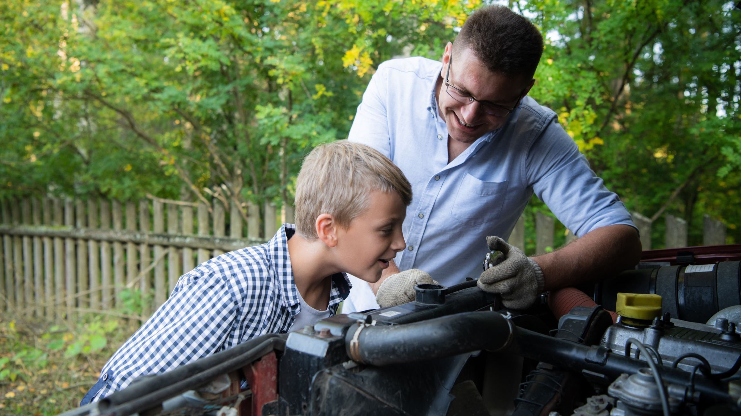 Dada and son working on a car AdobeStock_310192886